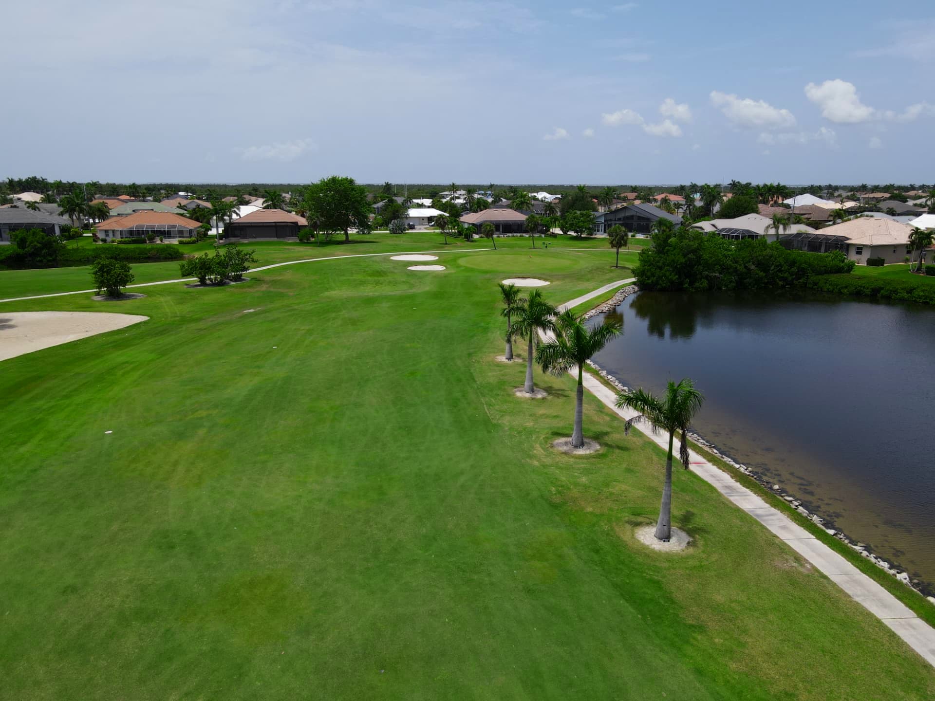 Wide fairway running alongside a lake toward a bunkered green