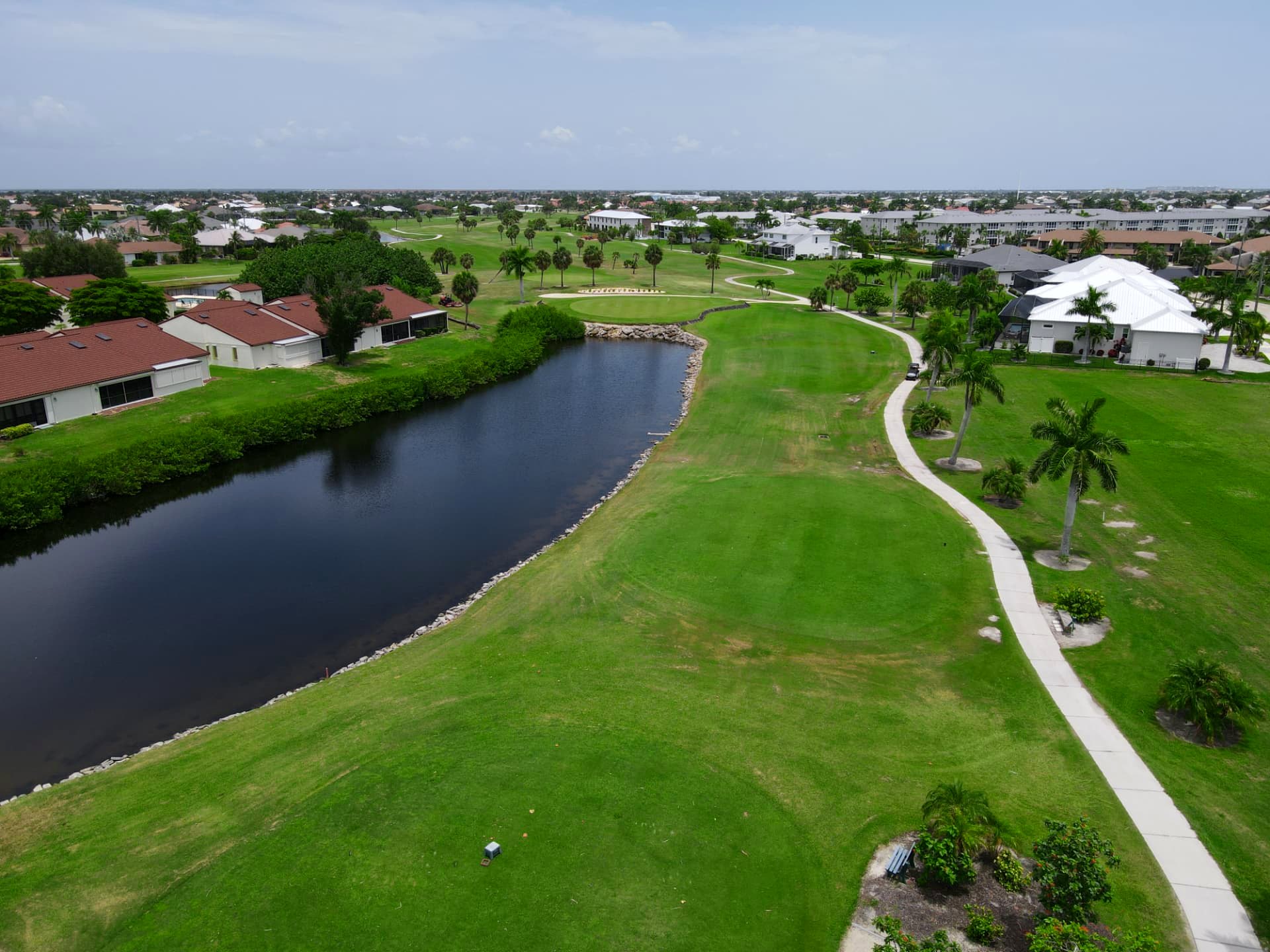 Fairway curving beside a lake with villas along the treeline