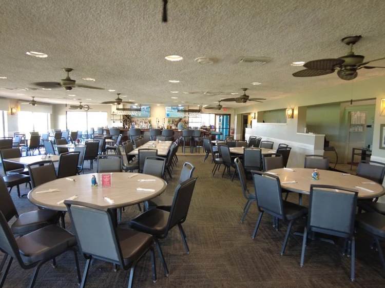 Dining room set with round tables looking toward the clubhouse bar
